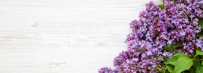 A bouquet of lilac flowers on a white wooden surface, overhead view. Copy space. Top view, flat lay.