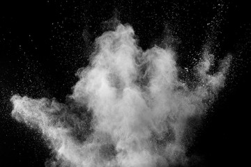 White powder explosion cloud against black background.White dust particles splash.
