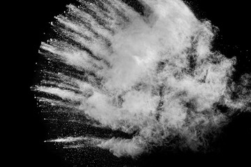 White powder explosion cloud against black background.White dust particles splash.