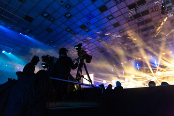 Television broadcast by a cameraman during a concert. Camera with the operator is on the high...
