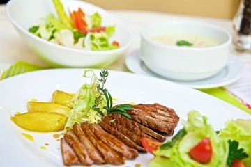 duck slices with pear slices and salad