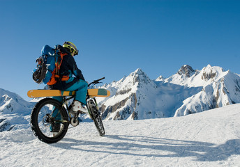 man with an electric bike, e-bike, ebike, mountains of Formazza Valley, ski loaded on bicycle, on path with snow and continue with skis, winter, sport, adventure, travel, Alps, Piedmont, italy