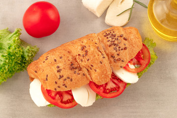 Croissant sandwich with lettuce mozzarella and tomato. Healthy snack. Top view