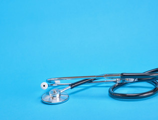 metallic medical stethoscope on a blue background