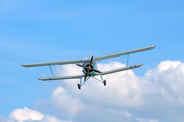 Old aeroplan on the background of blue sky with clouds