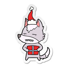 sticker cartoon of a wolf with a gift wearing santa hat