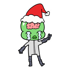 line drawing of a big brain alien crying and giving peace sign wearing santa hat