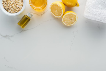 Fototapeta na wymiar top view of lemons, honey, oat flakes and various ingredients for cosmetics making on white surface