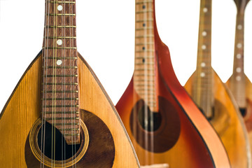 Fototapeta na wymiar Four mandolins close up. Isolated on a white background. Selective focus.