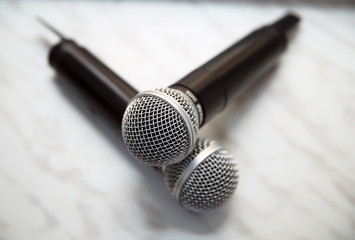 Two silver microphones isolated over white background . Two wireless microphones on the conference...