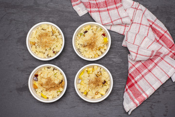 Uncooked chopped mixed fruits. recipe step by step crumble with fruits in a ceramic ramekin flatlay on grey stone