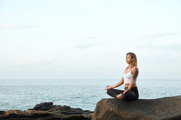 Fototapeta na wymiar Woman Practicing Yoga in the Nature. Meditating Outdoors