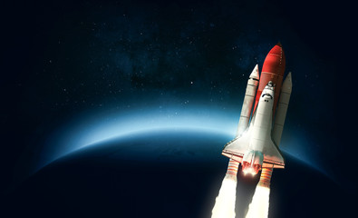 Space shuttle in space over the Earth. Elements of this image furnished by NASA