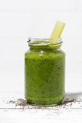 healthy green fruit and vegetable smoothies with chia seeds in jar on white table, vertical