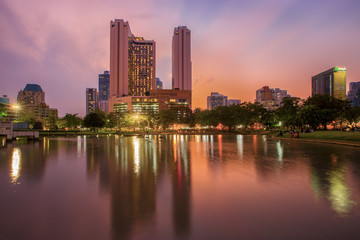 Fototapeta na wymiar Bangkok business district with the public park area in the foreground at sunset time