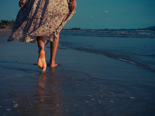 Women wearing vintage dresses are walking on the beach with excitement to relax. Summer beach trips...