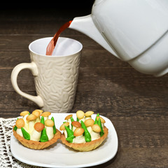 Cakes and tea poured into Cup from teapot