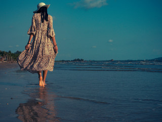 Women wearing vintage dresses are walking on the beach with excitement to relax. Summer beach trips...