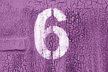 Number 6 in stencil on grungy metal wall in purple tone.