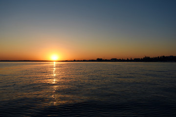 Obraz premium sunset over the calm black sea with seagulls