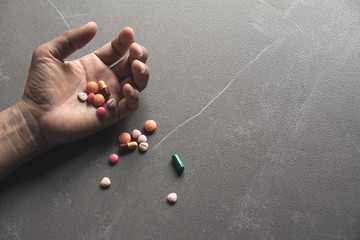 The man committing suicide by overdosing on medication. Close up of overdose pills and addict.
