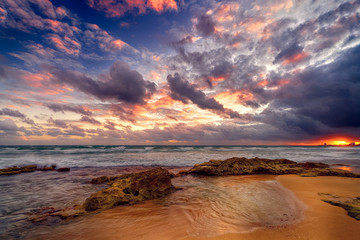 Dramatic sunrise low hanging clouds over wavy blue ocean at San Juan, Peurto Rico - obrazy, fototapety, plakaty