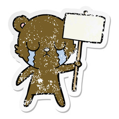 distressed sticker of a crying cartoon bear with sign