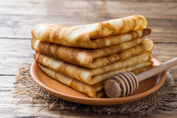 Thin pancakes stacked on a wooden background. Copy space.