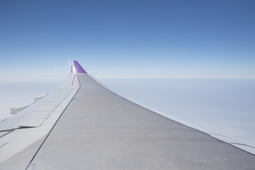Fototapeta na wymiar Airplane wing against blue sky
