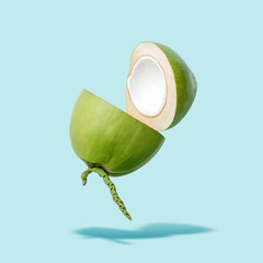 Flying green coconut on a blue background, creative summer food concept, floating young coconut in...