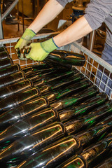 in an winery already filled bottles of wine are placed into a skeleton container