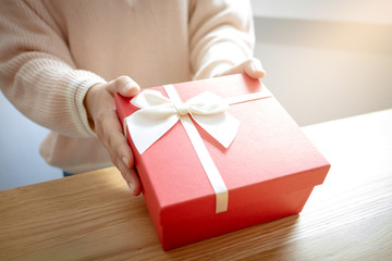 hands of woman present a red gift box, surprise for valentine concept.