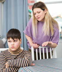 Mother and  offended son arguing in domestic interior