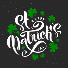 Naklejka premium Happy St. Patrick Day lettering on grey background with green trefoils. Beautiful Vector illustration for greeting card/poster/banner template.