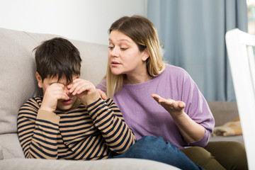 Mother and  offended son crying during  arguing in domestic interior