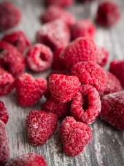 Frozen raspberries on a wooden tabletop. Closeup.