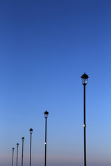 Lamp posts against a crisp blue sky UK