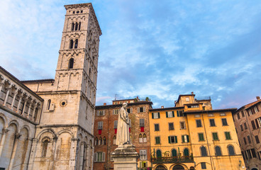 Fototapeta na wymiar Bell tower of Chiesa di San Michele in Foro St Michael Roman Catholic church and monument in historical centre of old medieval town Lucca, evening view, cloudy blue sky background, Tuscany, Italy