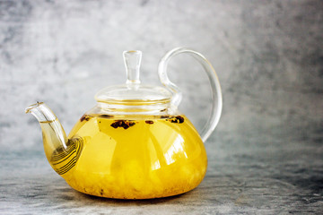 Spice fruit tea in a transparent teapot. Tea with pineapple, sea buckthorn, cinnamon, star anise,...