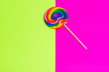 Colorful rainbow lollipop swirl on wooden stick happy bright color surge background. Summer Vacation, birthday party, invitation, greeting card concept.Copy space.Top view.