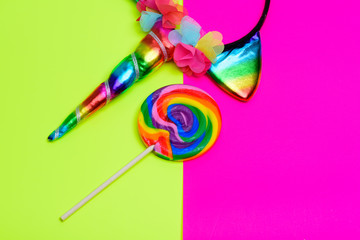 Unicorn headband, Colorful rainbow lollipop swirl on wooden stick over happy bright color surge background. Summer Vacation, birthday party, invitation, greeting card concept.Copy space.Top view..