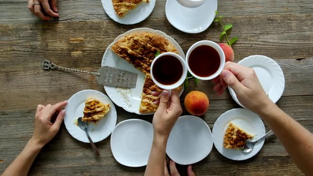 Friends Tea Party with amazing peach pie, big peaches, mint on the wooden table. Top view.