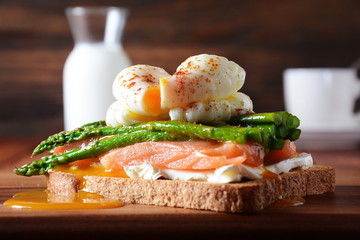 Poached egg with fried asparagus, cream cheese, salmon and spices on a toast. Poached egg with leak.Healthy French breakfast concept