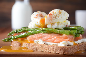 Poached egg with fried asparagus, cream cheese, salmon and spices on a toast. Poached egg with leak.Healthy French breakfast concept