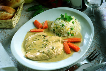 Plato con pechuga de pollo a la pimienta verde, con arroz hervido con guisantes y zanahoria.