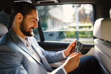 Businessman using digital tablet in a taxi