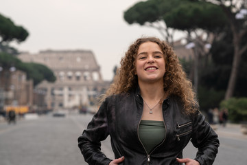 Fototapeta na wymiar Happy young woman enjoys her visit to Rome, Italy, in front of the coliseum