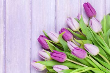 Purple tulips on wooden table