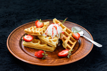 Breakfast. Viennese waffles with strawberries, cherries, summer berries on a plate on a black background