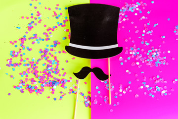 Happy Father’s Day greeting card. Flat lay style. Design with mustache, black hat and confetti on bright background.